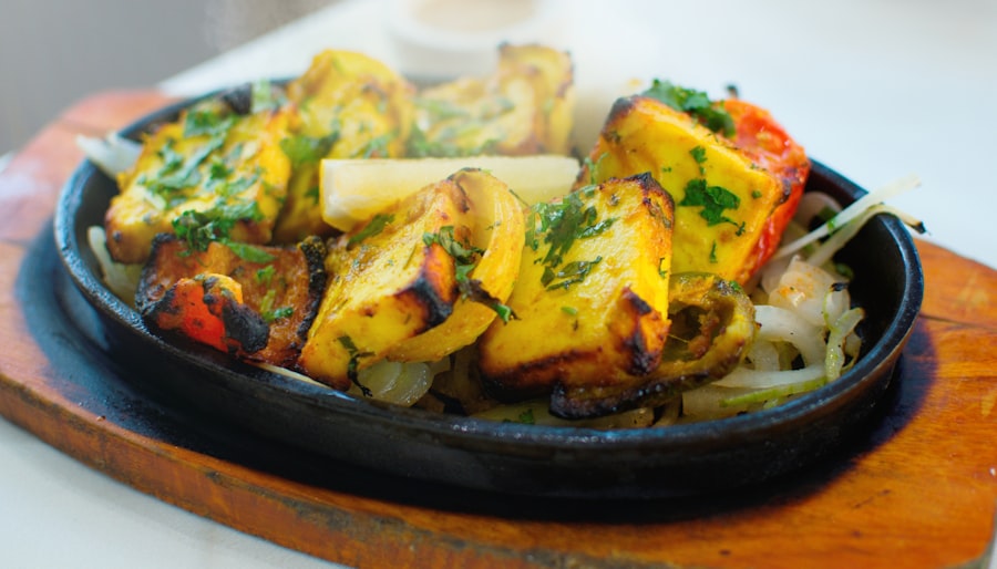 Paneer tikka skewers on a sizzling platter